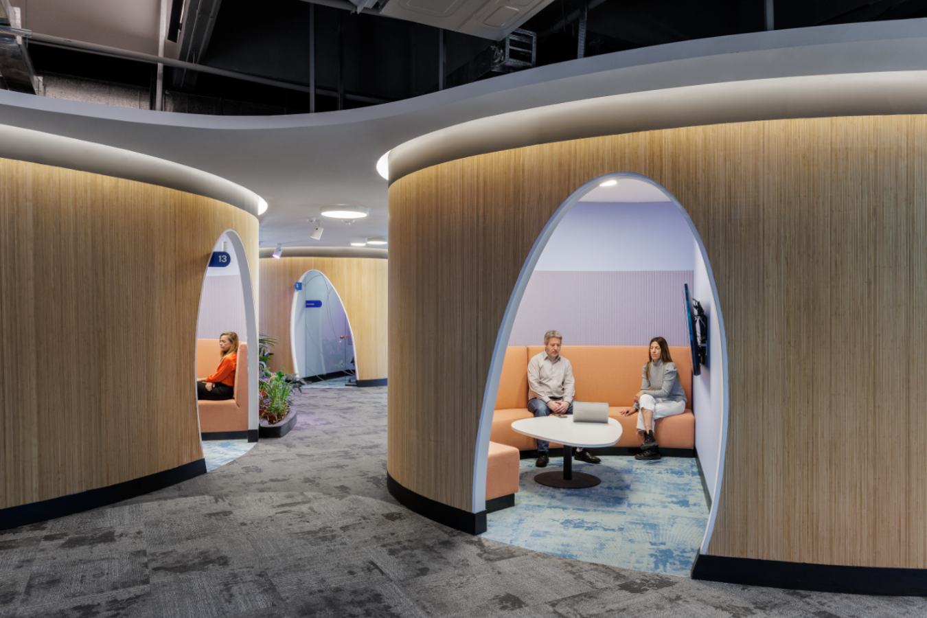 Uala Offices 2024 - Curved acoustic meeting pods with warm wood paneling and colorful interiors - Contract Workplaces.jpg